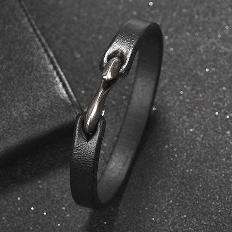 Side close-up of black gothic leather bracelet clasp mechanism, vintage boat hook fastener detail