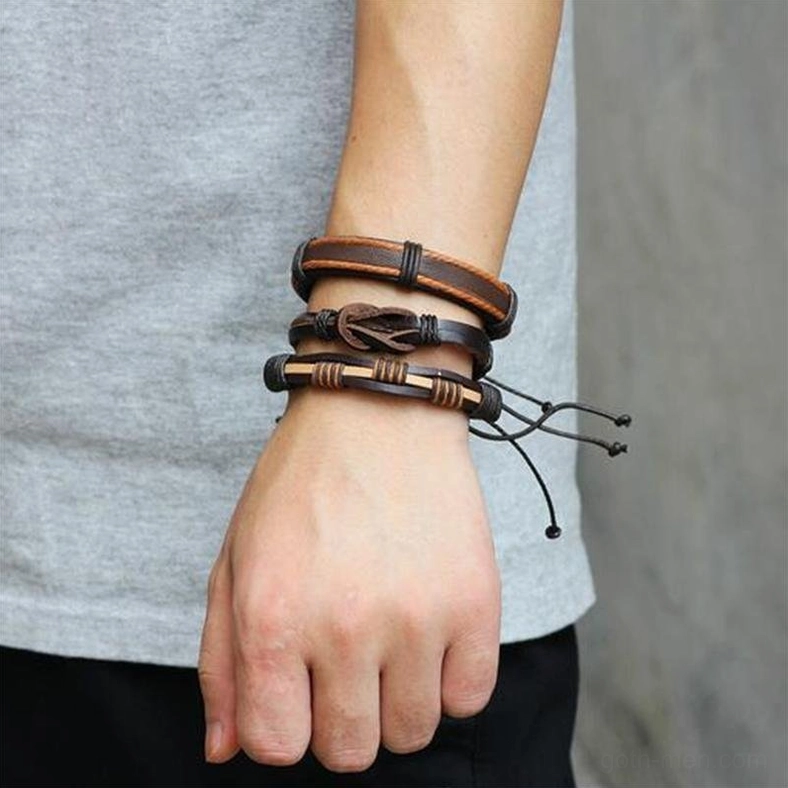 male model wearing stacked gothic leather bracelets layered on forearm side view