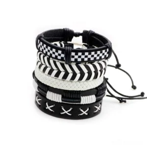 Black and white leather gothic bracelet set featuring checkerboard, chevron, and cross-stitch patterns - flat lay product view