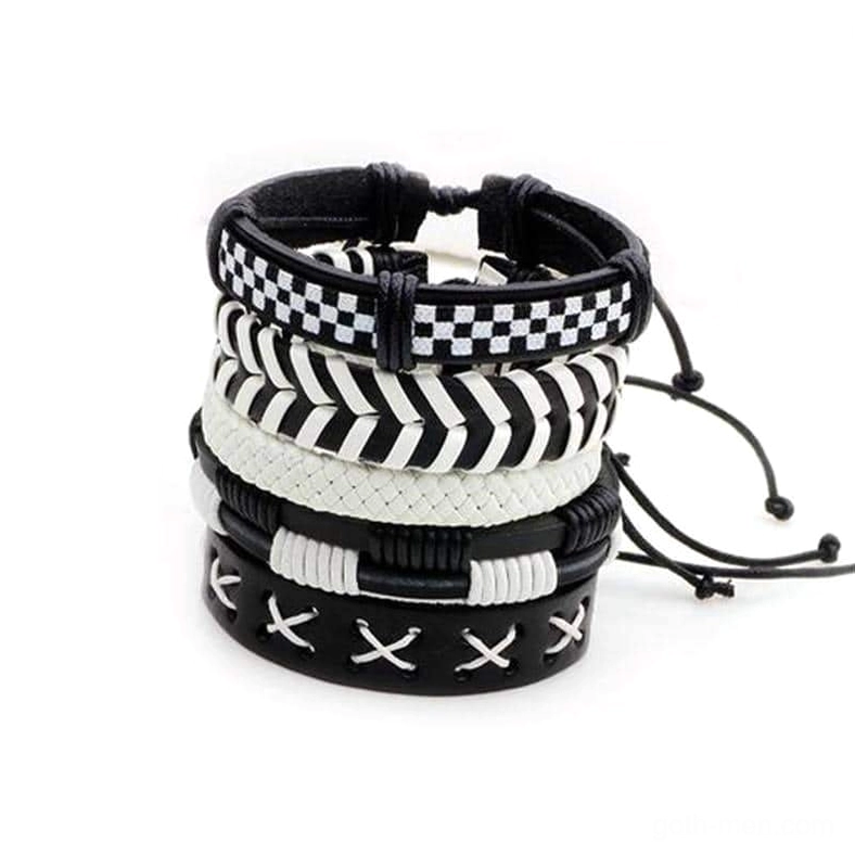 Black and white leather gothic bracelet set featuring checkerboard, chevron, and cross-stitch patterns - flat lay product view