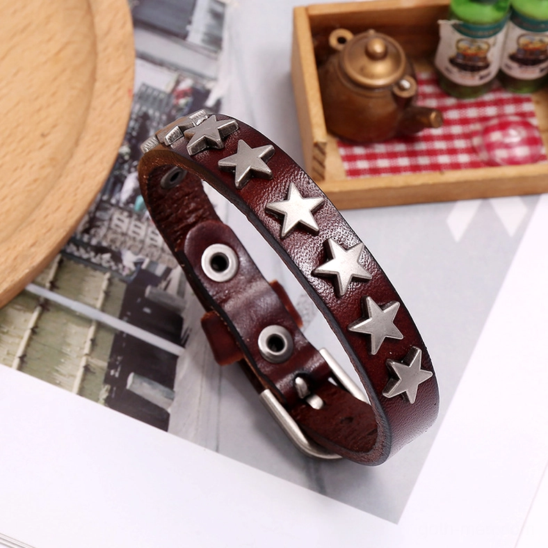 Three-piece gothic star leather bracelet collection arranged on vintage table surface showing color variations and texture details