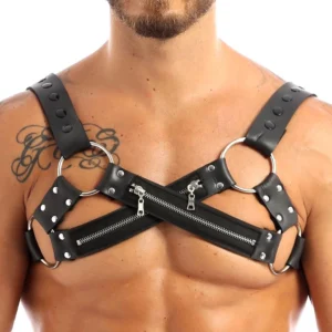 Men's black faux leather gothic chest harness with X-shaped cross straps and silver zippers worn on tattooed model front view