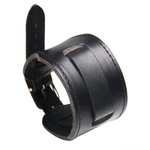 Black genuine leather gothic wristband cuff with metal buckle fastener and reinforced stitched seams, front view on dark background