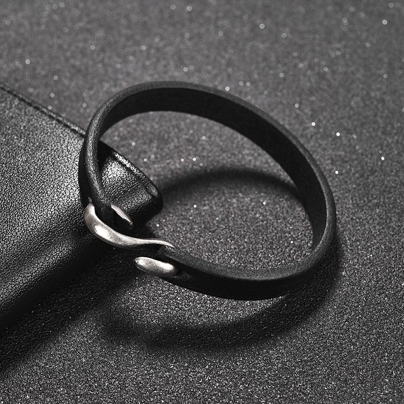 Overhead close-up of black genuine leather gothic bracelet with detailed vintage boat hook metal clasp, matte finish