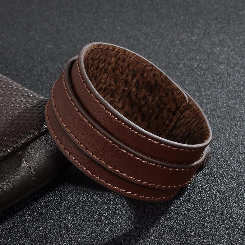Brown double-layer gothic leather cuff with stitched edges and fuzzy inner lining, oblique side view