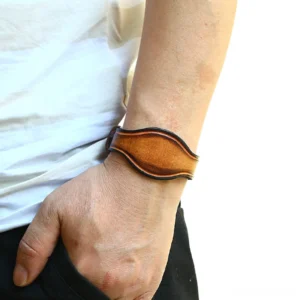 Wide brown genuine leather gothic cuff bracelet worn on male wrist - side view showing distressed vintage finish and antique bronze hardware