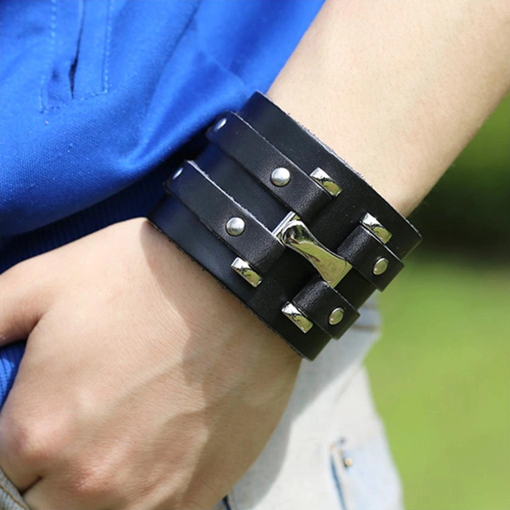Adult wrist wearing black braided leather gothic cuff bracelet outdoors lifestyle wear shot