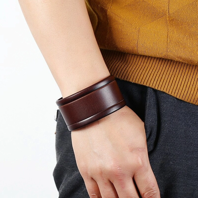 Wide leather gothic cuff bracelet worn on wrist in casual daily outfit, side wearing view