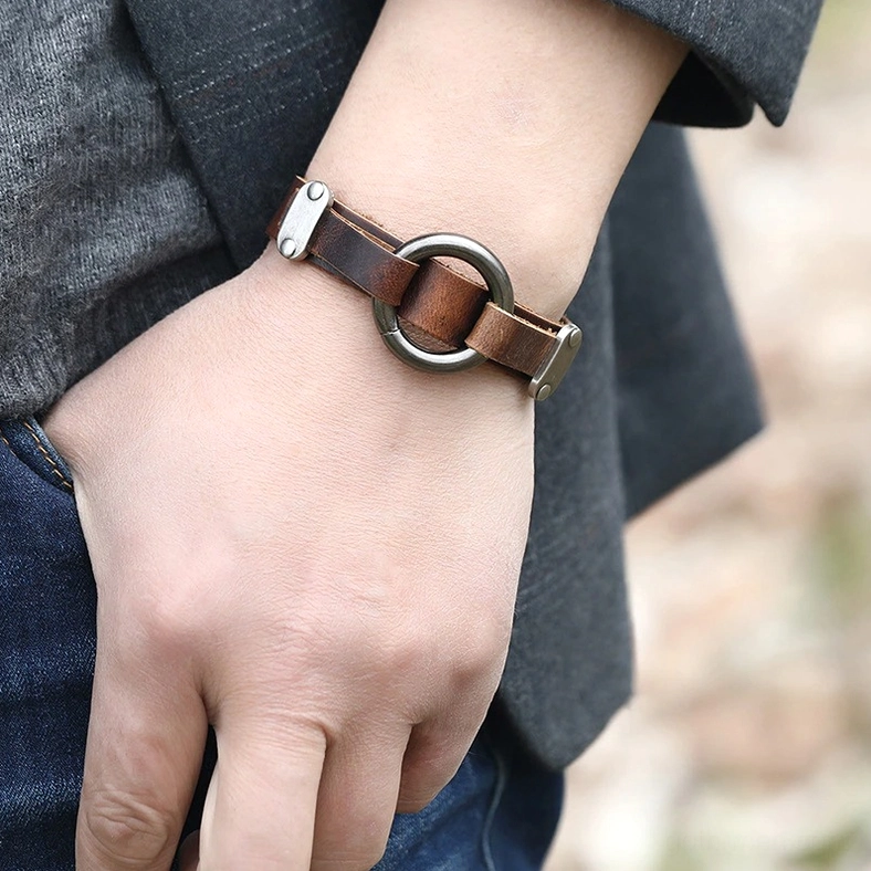 Men wearing vintage gothic leather cuff bracelet on wrist, outdoor casual setting showing real-world styling with dark metal alloy ring
