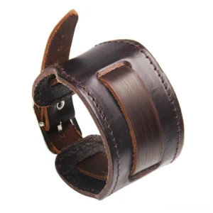 Wide genuine leather gothic cuff bracelet in rich brown, showing stitched edges and stainless steel buckle closure with decorative leather patch detail