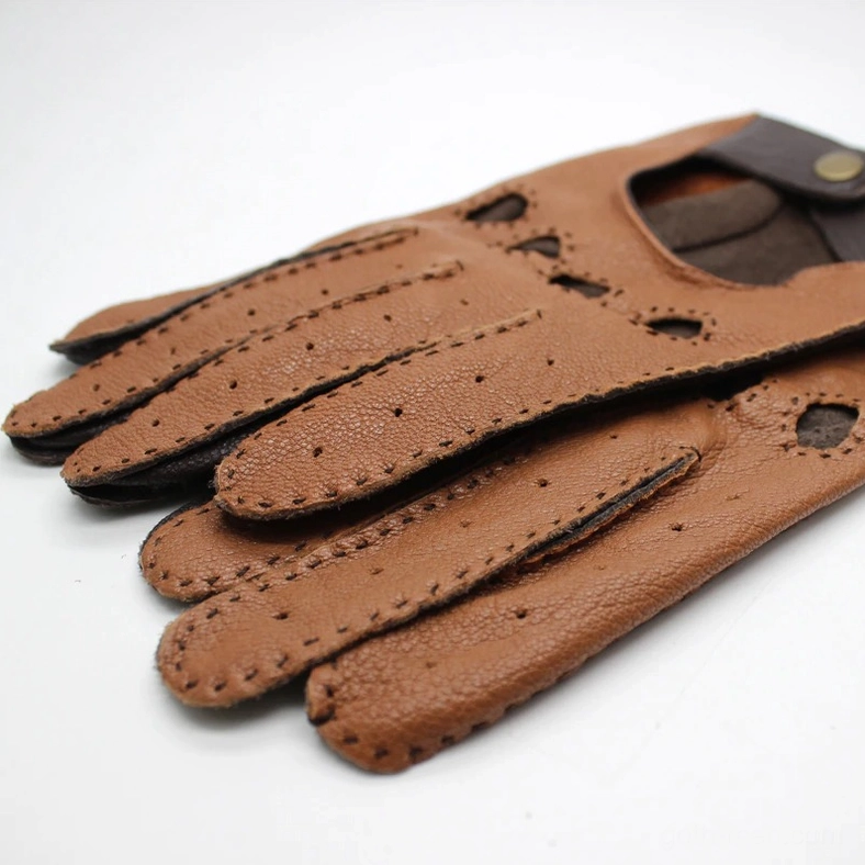 Stacked dark leather gothic riding gloves showing contrast stitching, ventilation holes, and folded wrist strap detail