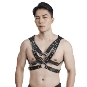 Black PU leather body harness front view worn by male model showing crisscross chest straps with metal contact loops