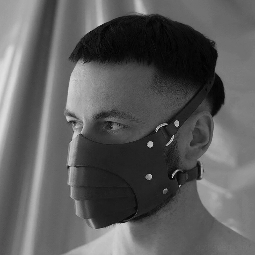 Black gothic leather face mask on short-haired male model, left angle view showing metal rivets and strap construction