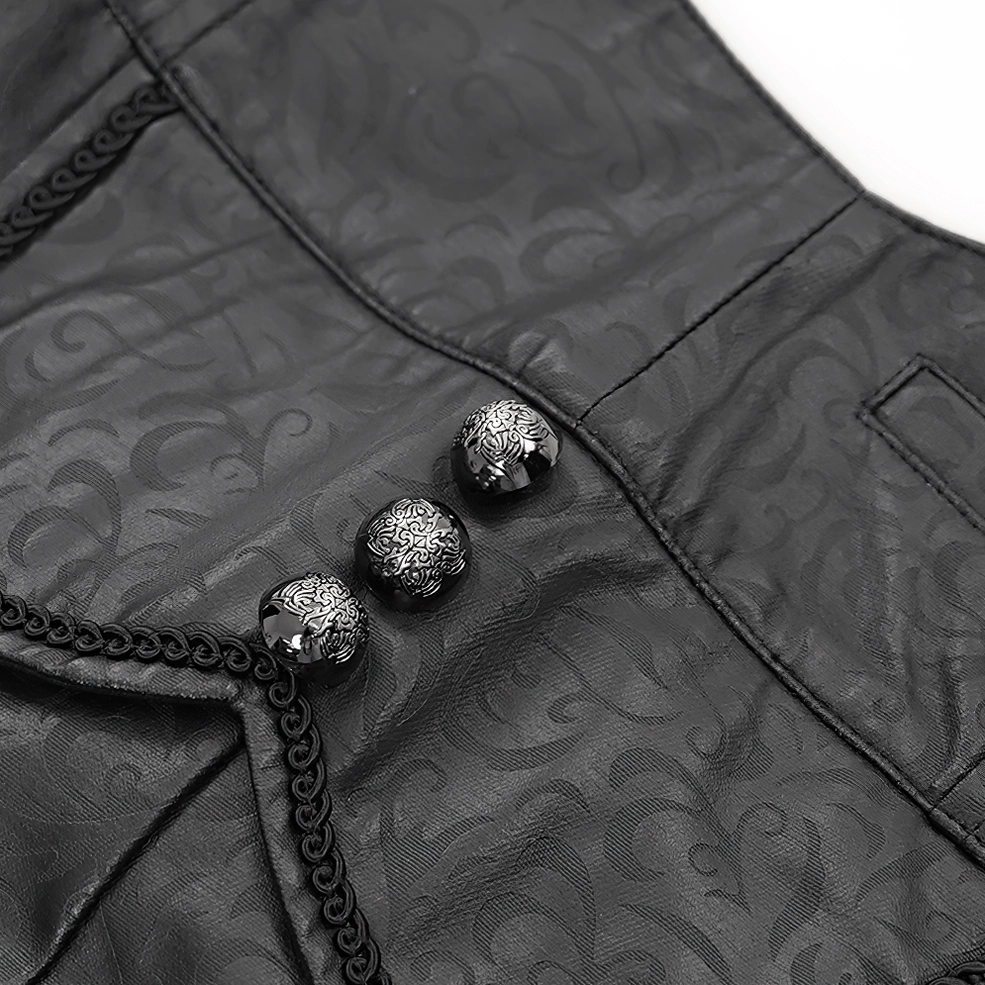 Close-up view of embossed damask pattern on black synthetic leather gothic pants front waistband with ornate chain trim