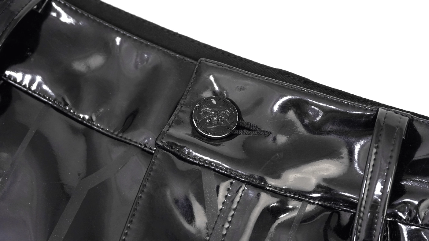 Black leather pants metal button closure and stitched seams detail close-up shot