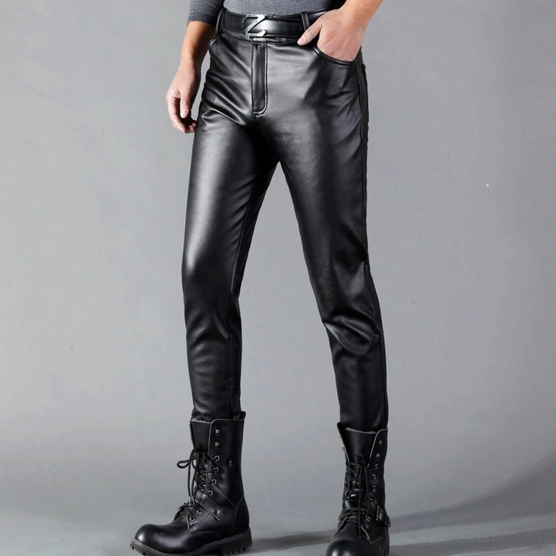 Men's black gothic leather pants side front view, male model with hand in front pocket, alternative fashion styling with accessories