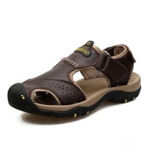 Dark brown leather gothic ankle strap sandals with perforated upper and adjustable hook-and-loop closure, three-quarter front view on white background