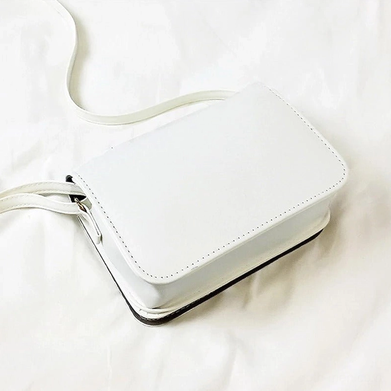 Rear view of white gothic letter crossbody bag showing back panel without print
