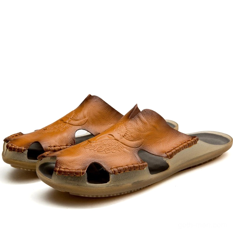 Light tan gothic men's leather slide sandals with hand-sewn details and carved floral patterns