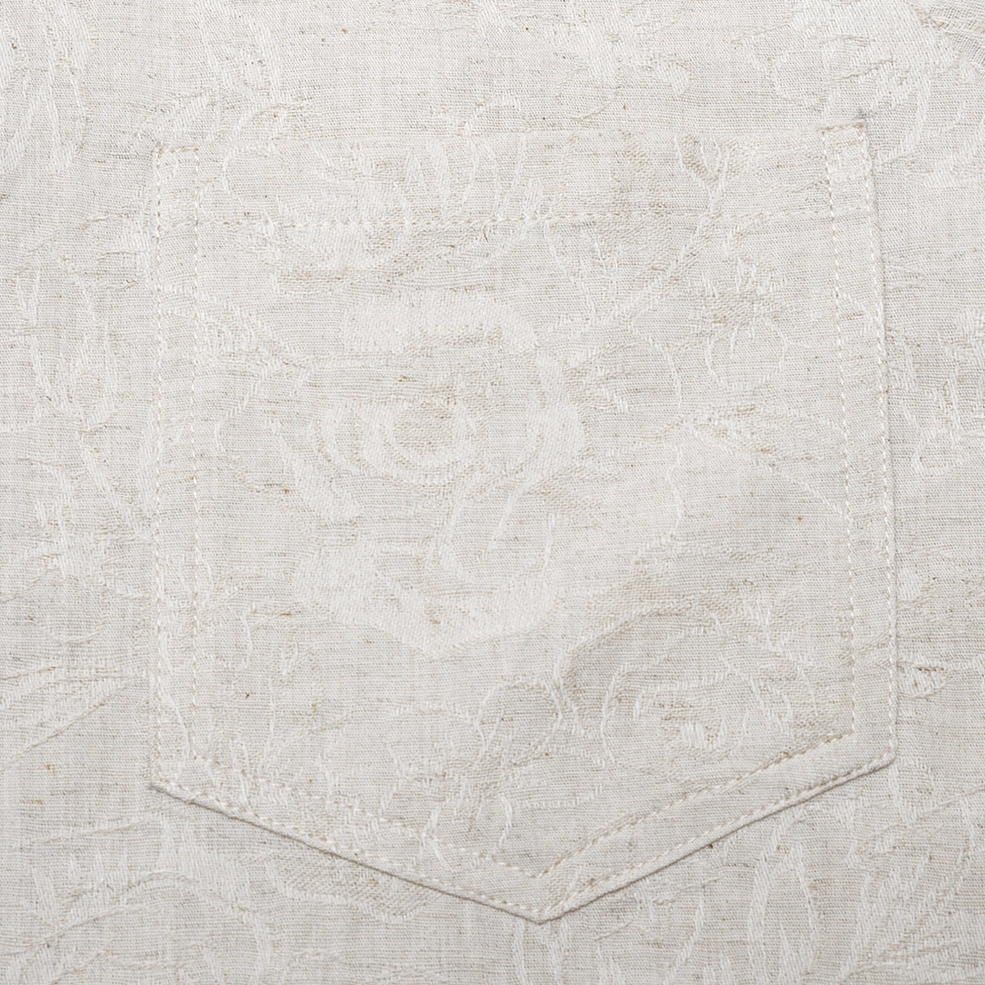 Detailed shot of chest pocket and embossed floral linen fabric texture with hand-stitched construction
