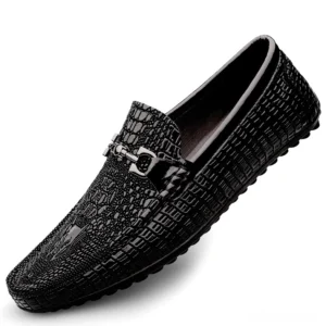 Men's black crocodile embossed leather gothic loafers with metal horse-bit buckle detail, front oblique angle view on white background