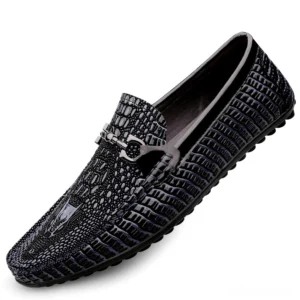 Black leather gothic slip-on loafers featuring crocodile embossing and metal decorative buckle, side angle view on white background