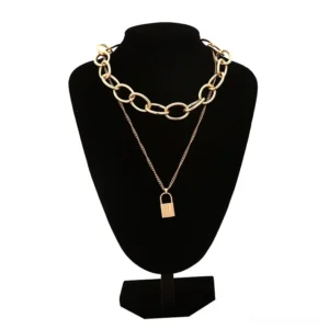 Gold-toned gothic lock pendant necklace with layered chain set on black jewelry mannequin