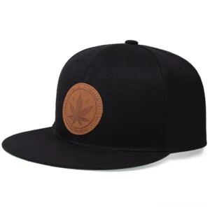 Black gothic flat-brim baseball cap with leather maple leaf badge, front three-quarter view