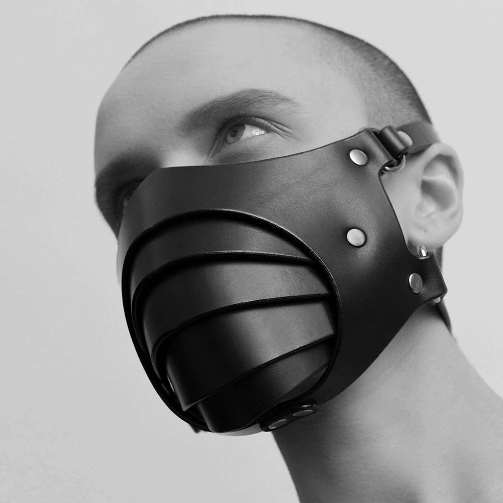 Adjustable gothic mask close-up showing matte black PU leather texture and professional rivet placement