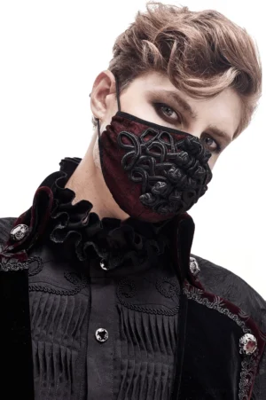 Wine red embroidered gothic mask worn by male model in formal goth attire with velvet ruffled collar, three-quarter view