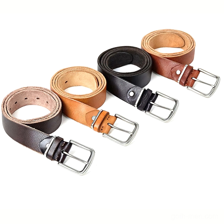 Overhead flat lay of four rolled gothic leather belts in assorted colors with matching silver pin buckles