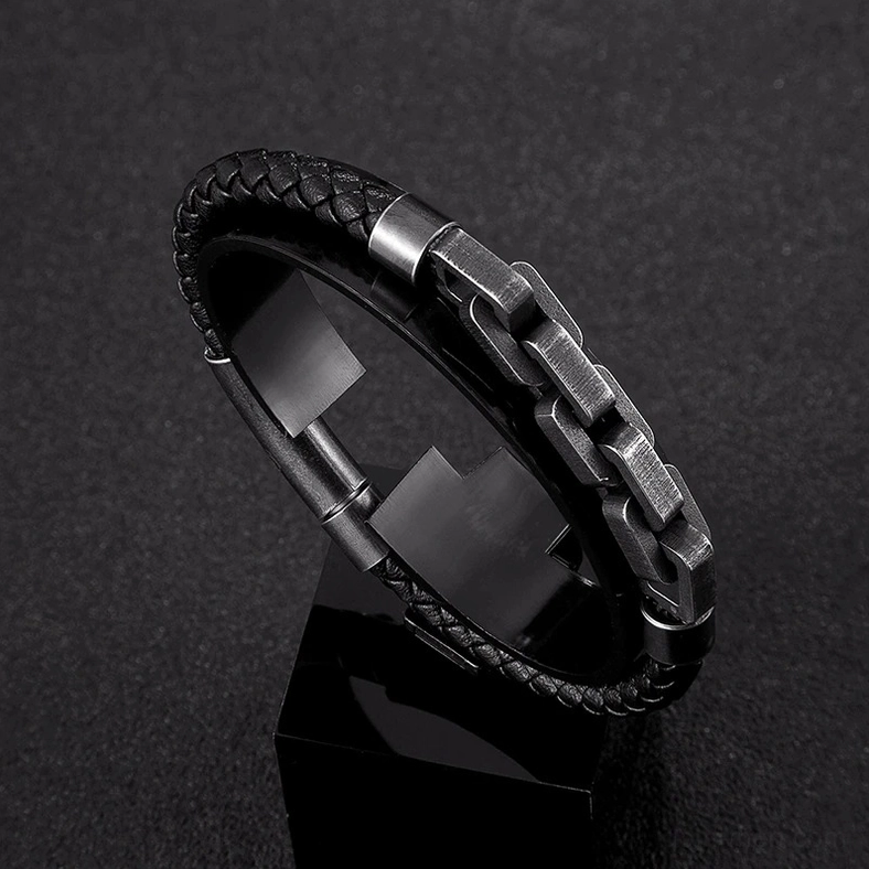Macro photography of men's gothic block chain bracelet showing polished gunmetal links and woven leather edge detail