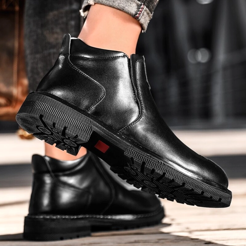 Gothic ankle boot lifted to showcase stitched rubber outsole, worn with light jeans, outdoor wooden floor
