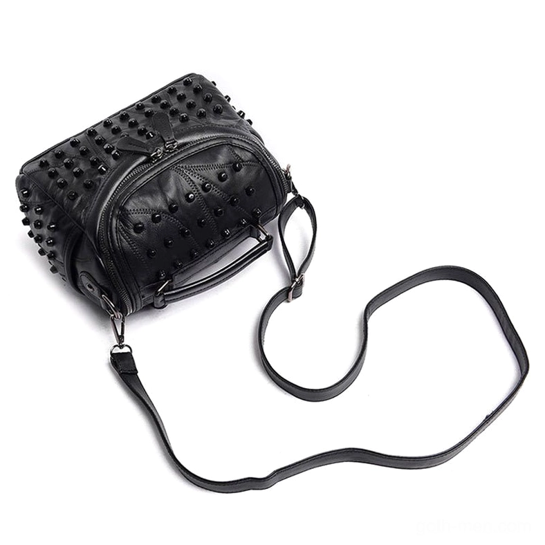 Compact black studded leather messenger bag side laydown view with detachable shoulder strap and top handle