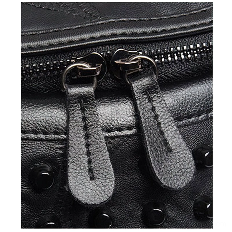 Black sheepskin messenger bag zipper hardware close-up showing pebbled leather texture and dual leather pulls