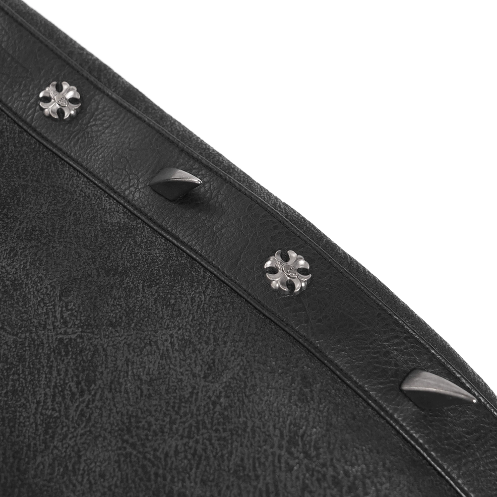 Detailed view of black faux leather spike studs and cross-shaped metal ornaments on gothic coat