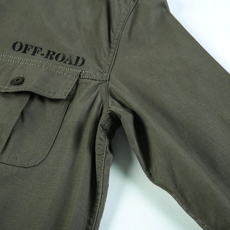 Close-up detail of olive green cotton fabric texture with branded tag and metal button craftsmanship