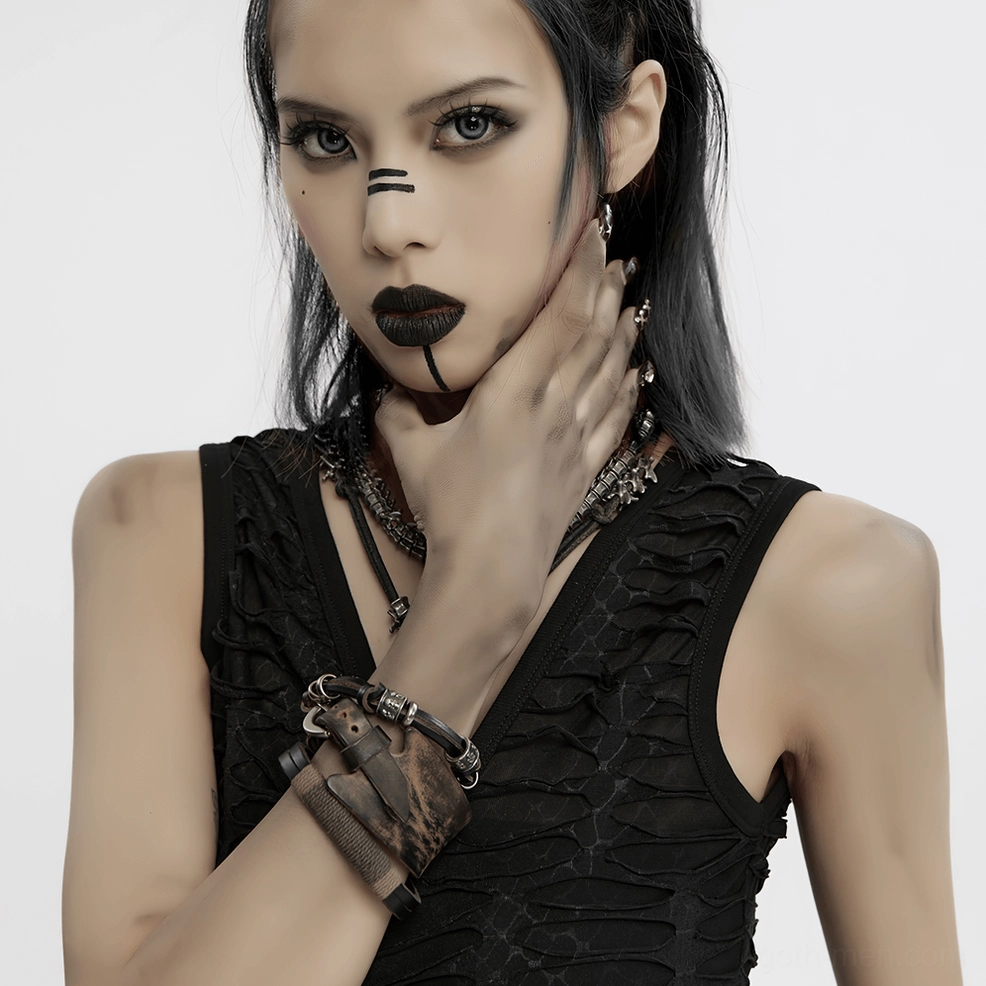 Gothic female model with dark makeup wearing vintage leather punk bracelets and layered necklaces, bust-up portrait shot, alternative subculture styling