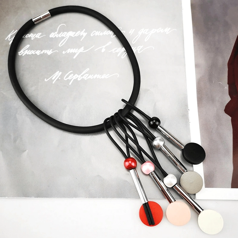 Styled flat lay of multicolor beaded silicone gothic choker showing black elastic band and dangling matte bead pendant arrangement