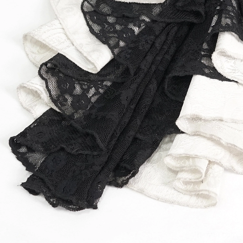 Close-up flat lay of gothic necktie fabric showing black lace overlay and textured white ruffled material composition