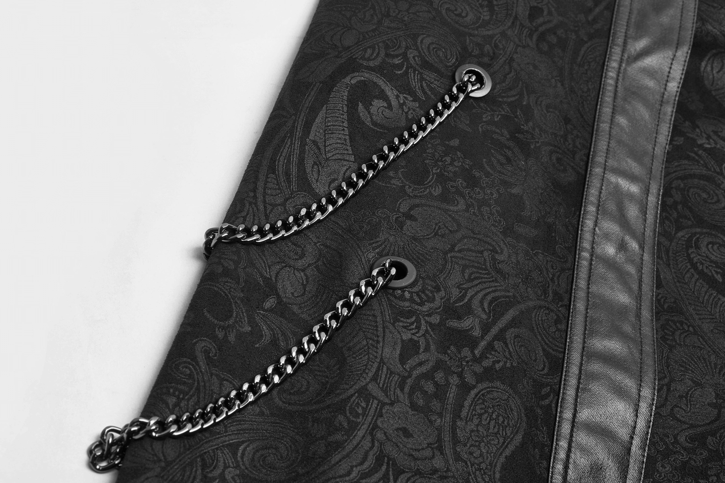 Close-up of decorative metal chains and eyelet fasteners on gothic overskirt