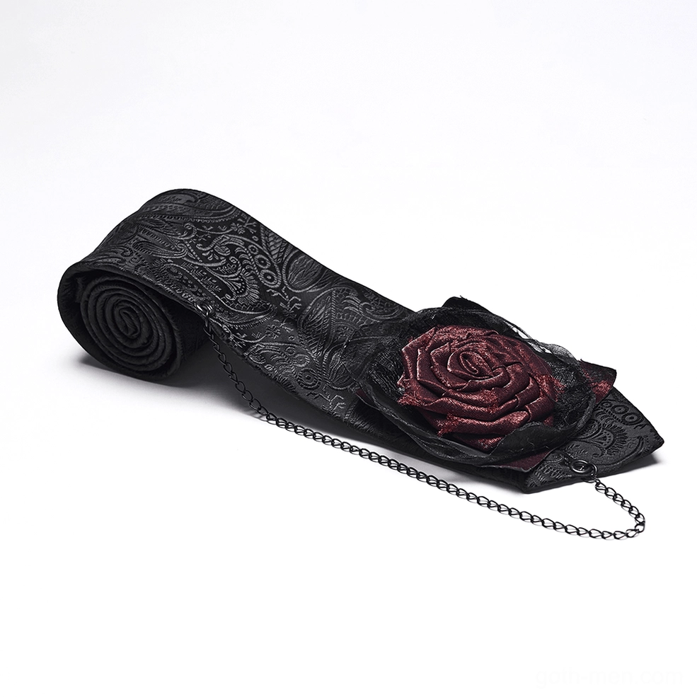 Gothic necktie oblique flat lay angle showing embossed paisley jacquard fabric, attached metal chain, and burgundy rose gothic decoration