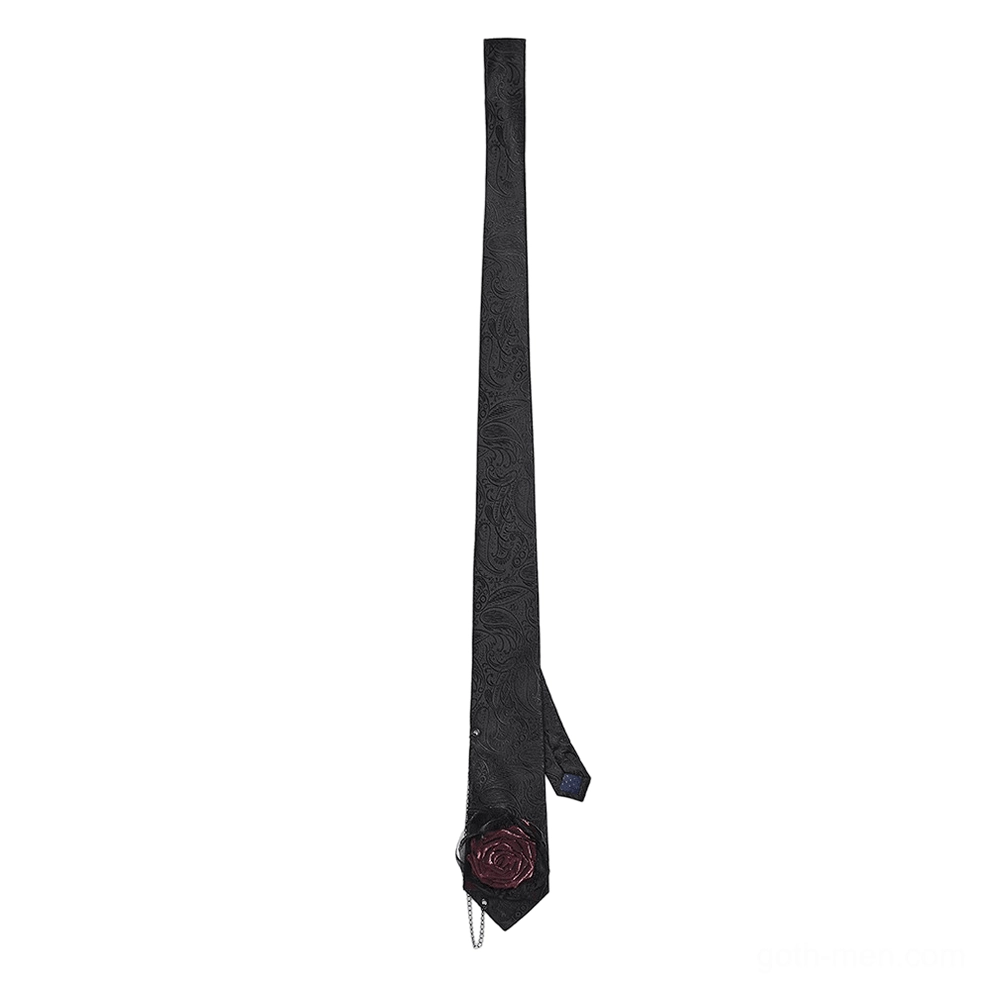 Black paisley gothic necktie side flat lay displaying burgundy rose decoration and chain pendant at tie tip