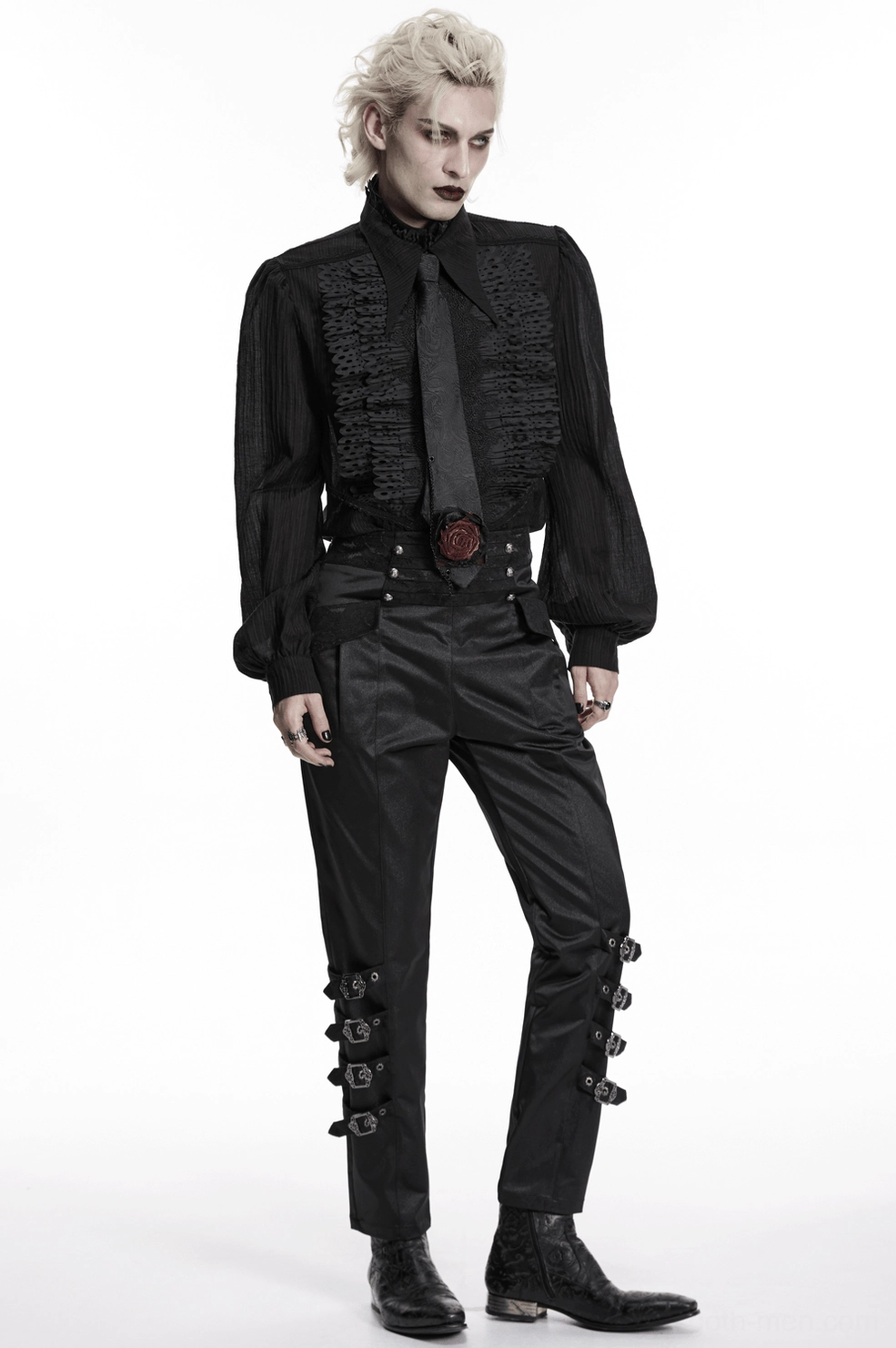 Androgynous model in three-quarter side view wearing black paisley gothic necktie with black leather boots, tailored goth trousers, and formal jacket