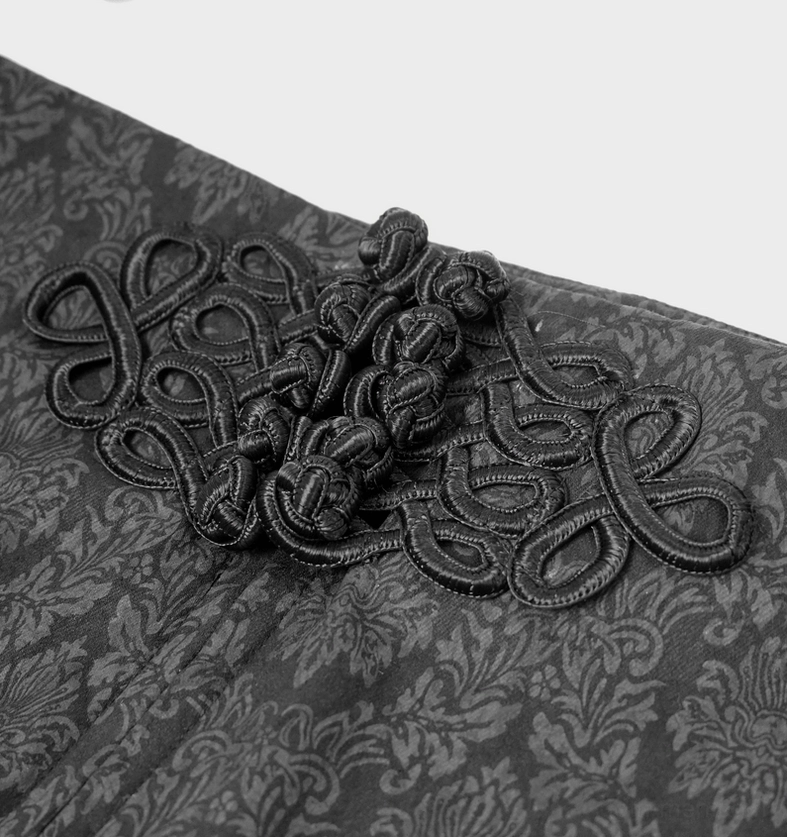 Close-up of black gothic pants front decorative knot, embroidered detail on damask jacquard fabric showing intricate weaving