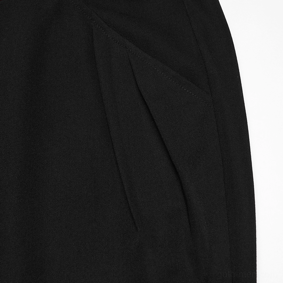Side view close-up of front pleats and tailored construction on black gothic pants