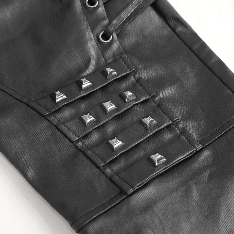 Close-up of pyramid metal studs on black leather knee panel