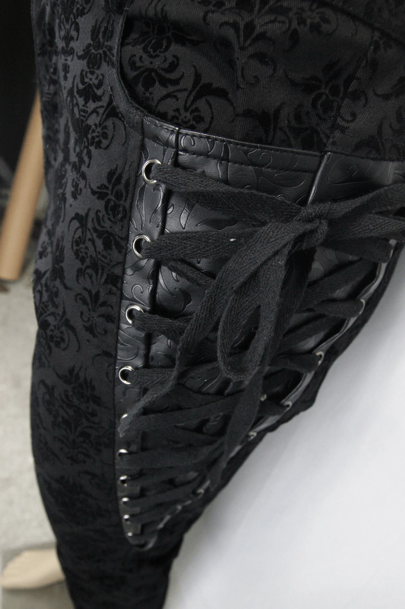 Side lace-up detail close-up of gothic steampunk pants showing leather lace trim, metal eyelets, and damask patterned fabric