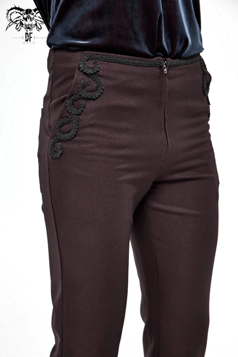 Detail shot emphasizing the semi-fitted waist construction and lace embroidery placement on men's gothic wine red trousers
