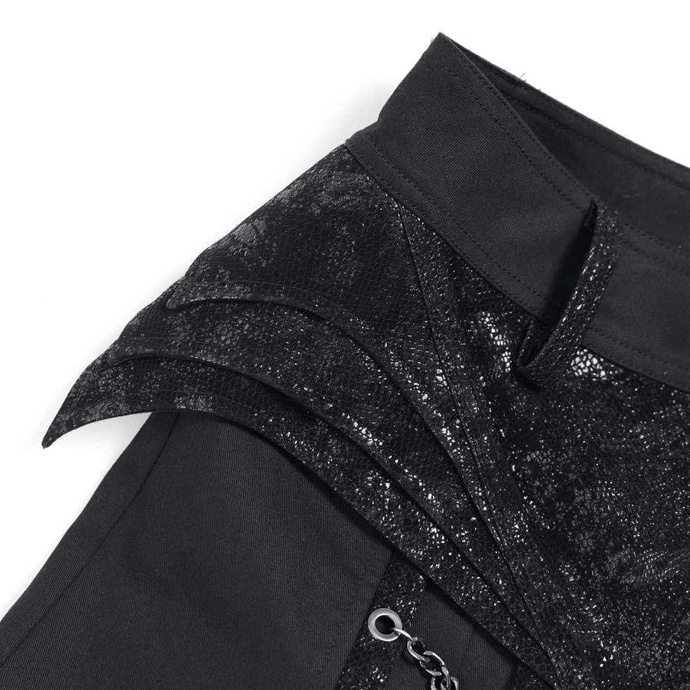 Close-up of black gothic pants waist featuring pyramid studs, zipper, and shimmering lace panel